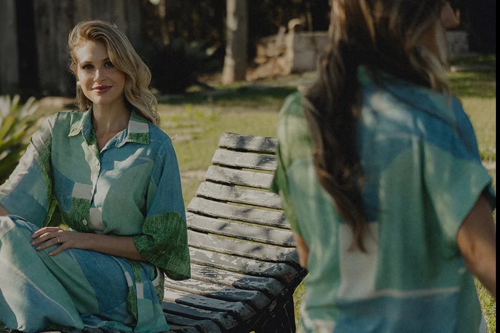 Duas mulheres ao ar livre vestindo camisas estampadas em verde e azul da Vizoo Brasil